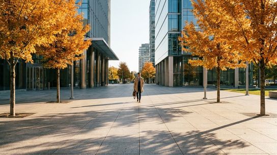 Modern Canadian city plaza with golden autumn maple trees under warm morning sunlight.